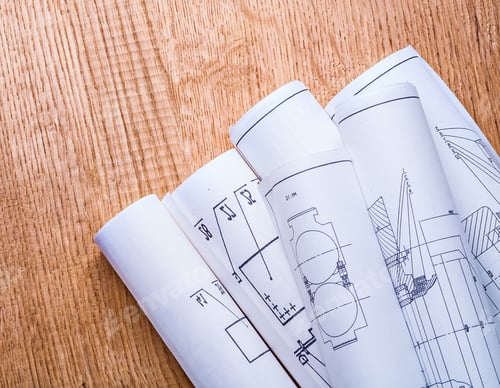 Preview: Little Pile Of White Blueprints On Brown Wooden Board Close Up View