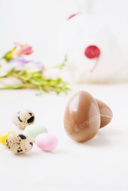Preview: Chocolate Easter Eggs Glazed With Pastel Coloring And Quail Eggs Over White Background. Happy