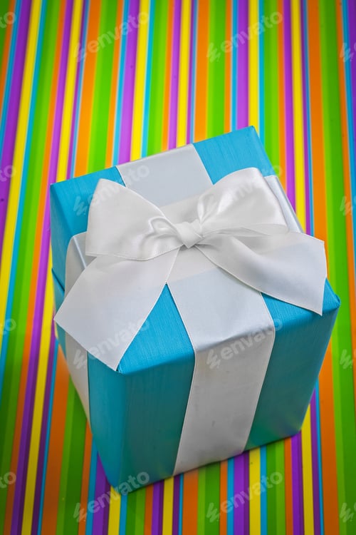 Preview: Classical Blue Gift Box With White Bow On Colored Striped Background