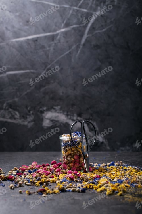 Visualização: Variedade de flores secas para fazer chá de ervas e tesouras de metal sobre fundo de textura escura