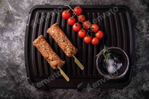 Preview: Raw Lamb Shish Kebabs With Tomatoes And Salt On The Grill Ready To Cook. Top View
