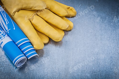 Preview: Yellow Protective Gloves Blue Construction Plans On Scratched Metallic Background.