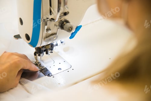 Preview: Woman Hands With Fabric At Sewing Machine. Seamstress Working Behind Her Equipment. Tailoring