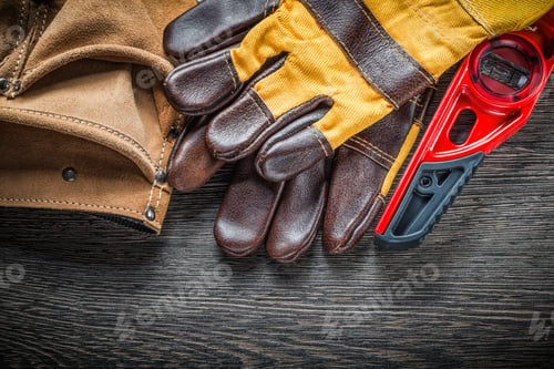 Preview: Construction Level Pair Of Safety Gloves Leather Tool Belt On Wooden Board.