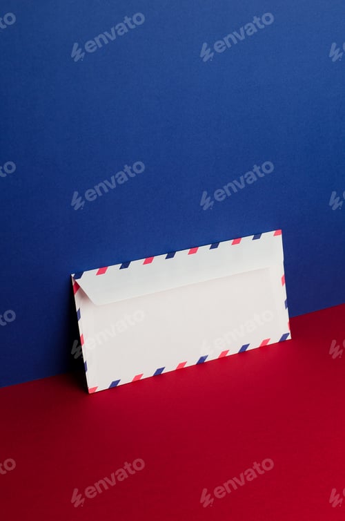 Preview: Envelope Tilted Over Blue And Red Background With Negative Space