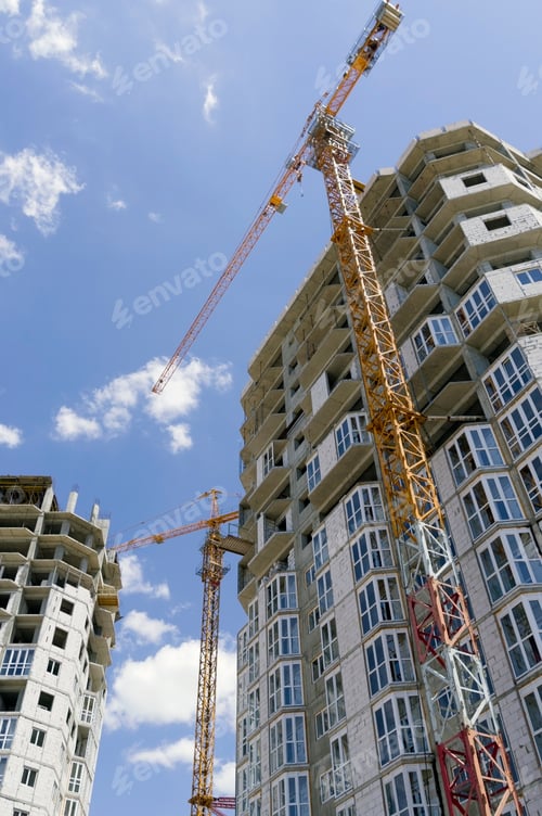 Preview: Building Crane And Building Under Construction Against Evening Blue Sky