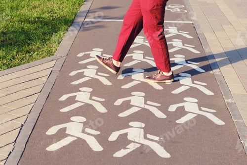 Preview: A Man Crosses A Bike Path In A Park At A Pedestrian Crossing