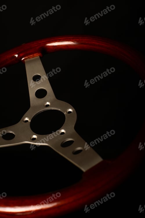 Preview: Detail Of A Wooden Vintage Steering Wheel On Black.