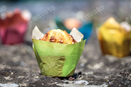 Preview: Delicious Muffins in Colorful Wrappers on Stone Surface