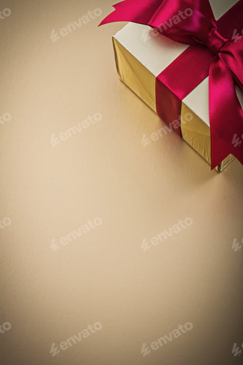 Preview: Boxed Gift With Tied Bow On Golden Background Holidays Concept.
