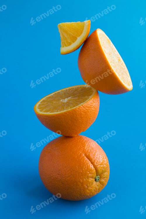 Preview: Orange Fruit Stacked Pyramid On The Blue Background.Close-Up. Location Vertical.