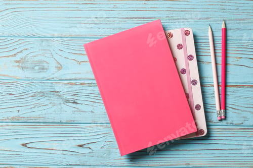 Preview: Pink Pencil With Notebook On A Blue Wooden Background. Place For Text