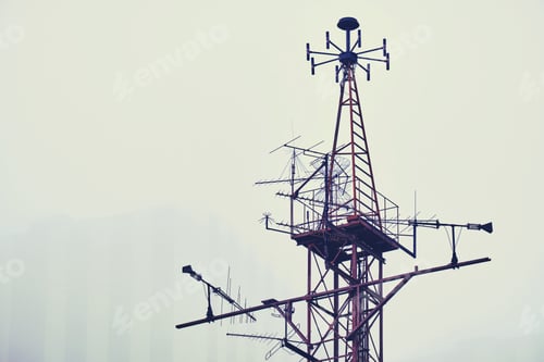 Preview: Metal Tower With Antennas For Various Purposes Against The Background Of A Smoky Sky