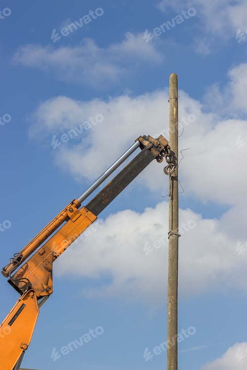Preview: Wooden Telephone Pole Hangs Vertically In The Air From A Yellow Crane. Crane Hook Lifting The