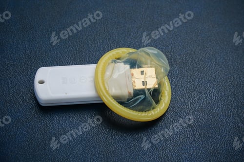 Preview: Unpacked Condom And Flash Drive On The Background Of A Leather Sofa, Toned