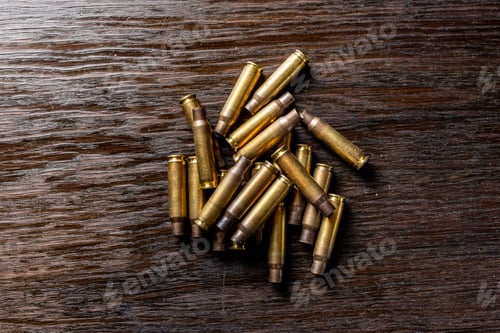 Preview: Empty Bullet Casings On A Dark, Wooden Table.