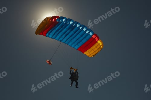 Preview: The Bright Multi-Colored Parachute Canopy With The Silhouettes Of The Instructor And Passenger