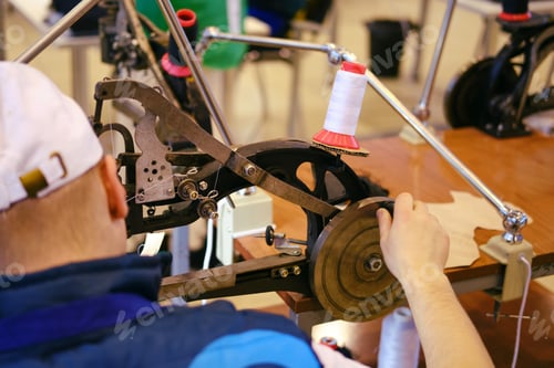 Preview: A Man Repairs Shoes On A Special Retro Sewing Machine For Leather
