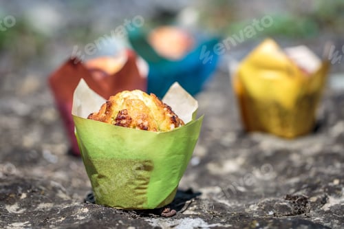 Preview: Fresh Muffins in Colorful Liners on Rock Surface