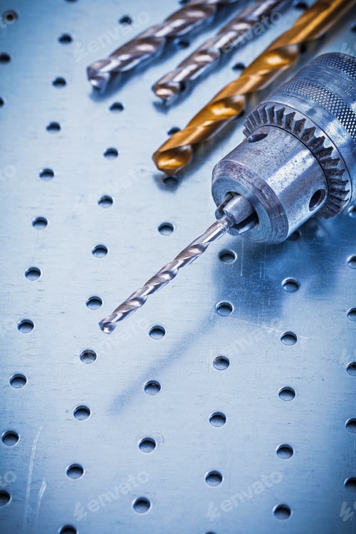 Preview: Metal Power Drill And Bits On Metallic Background Construction Concept.