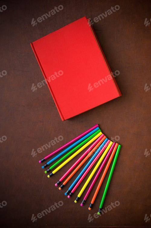 Preview: Wooden Writer Desktop With Colorful Pencil And Red Empty Cover Book, Vertical Frame