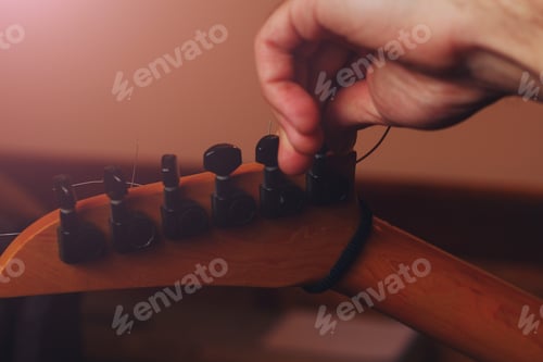 Preview: Hand Of A Musician Tuning A Guitar In The Darkness Of A Music Studio, Toned Background