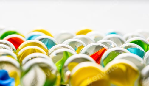 Preview: Yellow, Green, Blue And Red Glass Marbles On A Table.