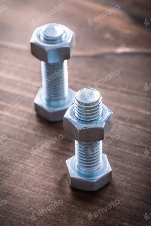 Preview: Couple Of Stainless Threaded Bolts And Screw Nuts On Vintage Wooden Board Construction Concept