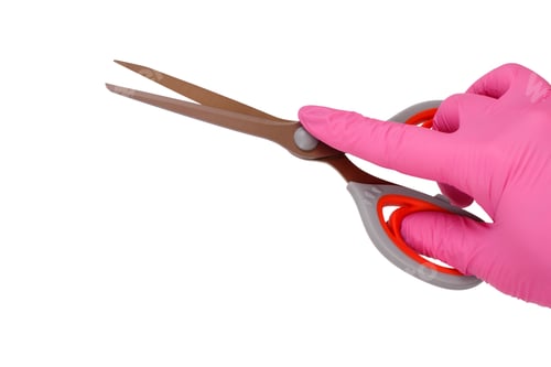 Preview: Female Hand In Pink Latex Glove Holding Scissors On White Isolated Background.