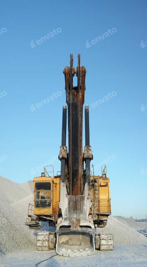 Preview: Excavator Stands Motionless On The Background Of A Pile Of Crushed Stone, Front Elevation, Vertical