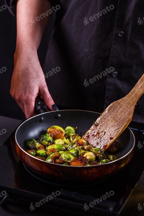 Preview: Young Woman Fries Brussels Sprouts On A Frying Pan