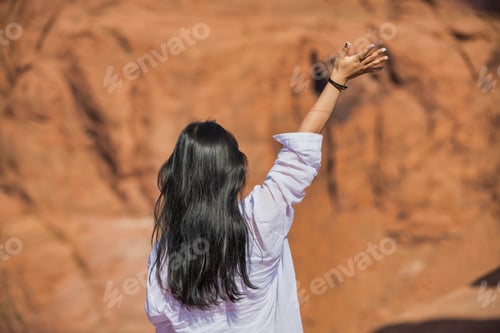 Preview: Asian Girl Standing On The Top Of A Rock Enjoying The Canyon And Waving With Her Arm, Back View.