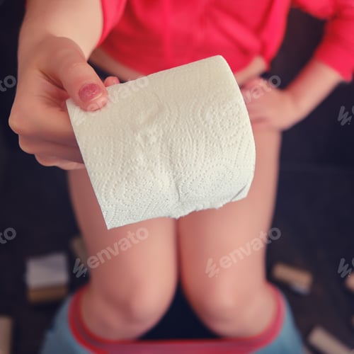 Preview: A Woman Sits On The Toilet And Holds Out A Roll Of Paper In Her Hand, Copy Space. Stay At Home