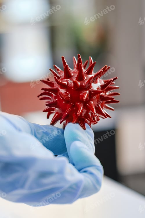 Preview: Red Virus Model Held in Blue Gloved Hand