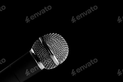 Preview: Close-Up Of A Modern Microphone With A Silver Mesh And A Black Handle, Isolated On A Black