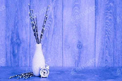 Preview: Spring Still Life. A Vase With Willow Branches And A White Alarm Clock Stand On The Table. Blue