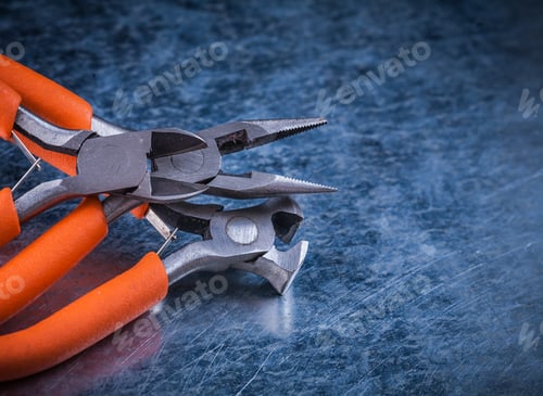 Preview: Composition Of Insulated Electric Pliers Nippers On Scratched Metallic Background.
