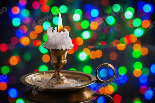 Preview: Glowing Old Candle In Wintage Candlestick On Surface Of Mirror With Multycolored Bokeh Horizontal