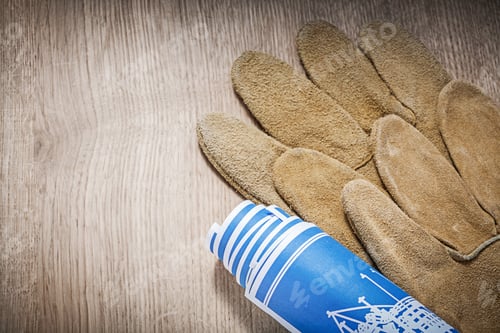 Preview: Leather Safety Gloves Blue Blueprints On Wooden Board Top View.