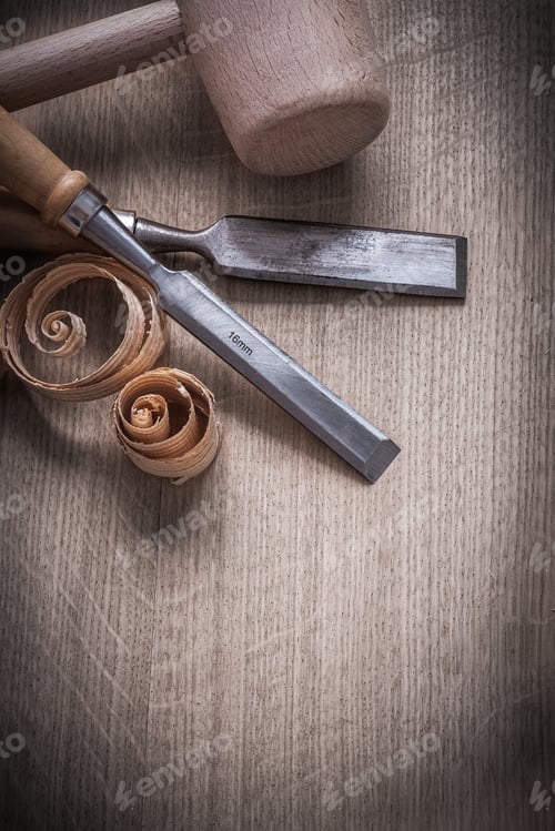 Preview: Wooden Hammer Curled Up Planning Chips Flat Chisels On Wood Board Construction Concept.