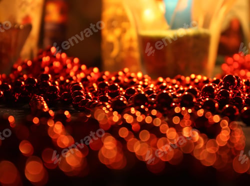 Preview: Red Beads In Warm Light Of Burning Colorful Candle Flame Background.