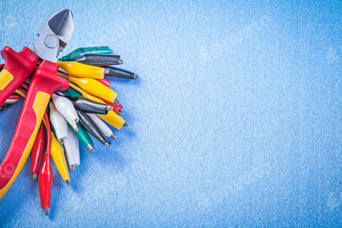 Preview: Set Of Multicolored Cable Crocodiles Cutting Pliers On Blue Background.