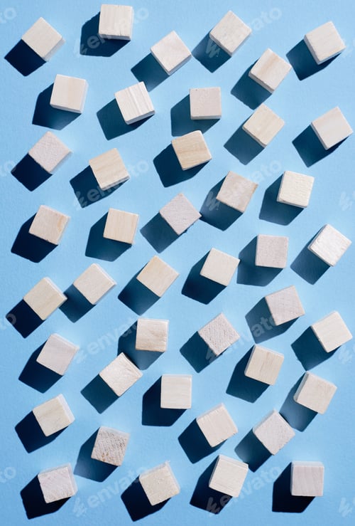 Preview: Wooden Cubes Spread Over Blue Background, Top View