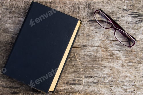 Preview: Old Closed Book And Glasses On Wooden Background
