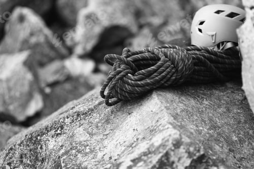 Preview: Helmet And A Bights Of Climbing Rope Lying On A Large Stone. Black And White.