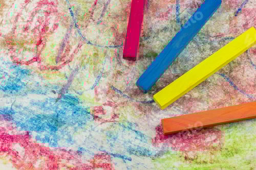 Preview: View Of A Group Of Differently Colored Chalk Lying On Colorful Drawings Of Paper