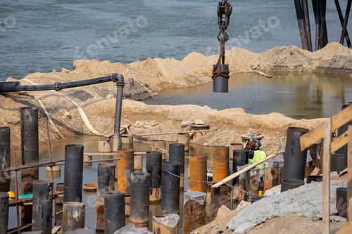 Preview: Row Of Construction Poles On The River Bank. Steel Pillars For Construction.
