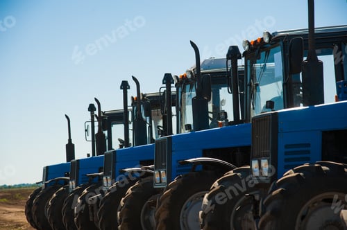 Preview: Row of New Blue Tractors Parked on Farm