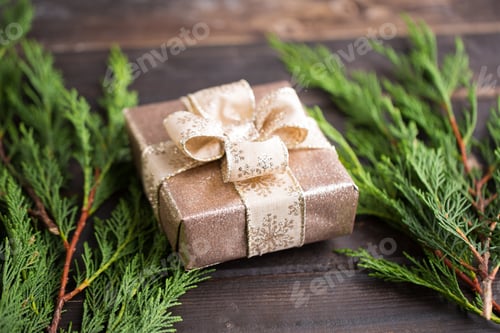 Preview: Gold Gift with Ribbon on Wooden Table