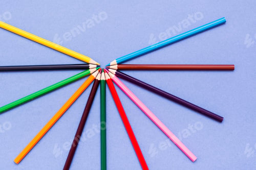 Preview: Color Pencils Are Spread Out On A Blue Background. Top View